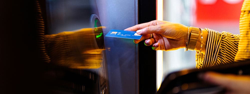 Individual standing with credit card at door