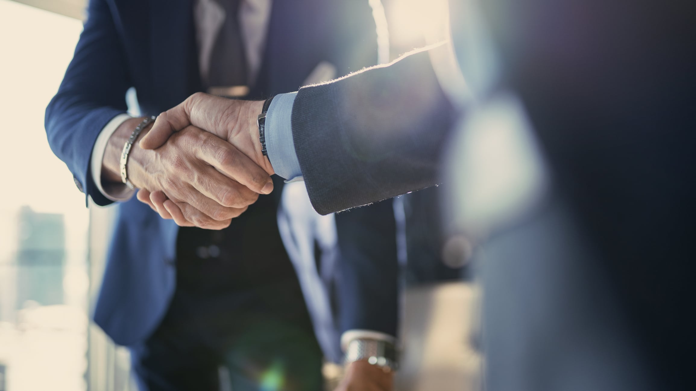 Two business professionals shaking hands in an office setting
