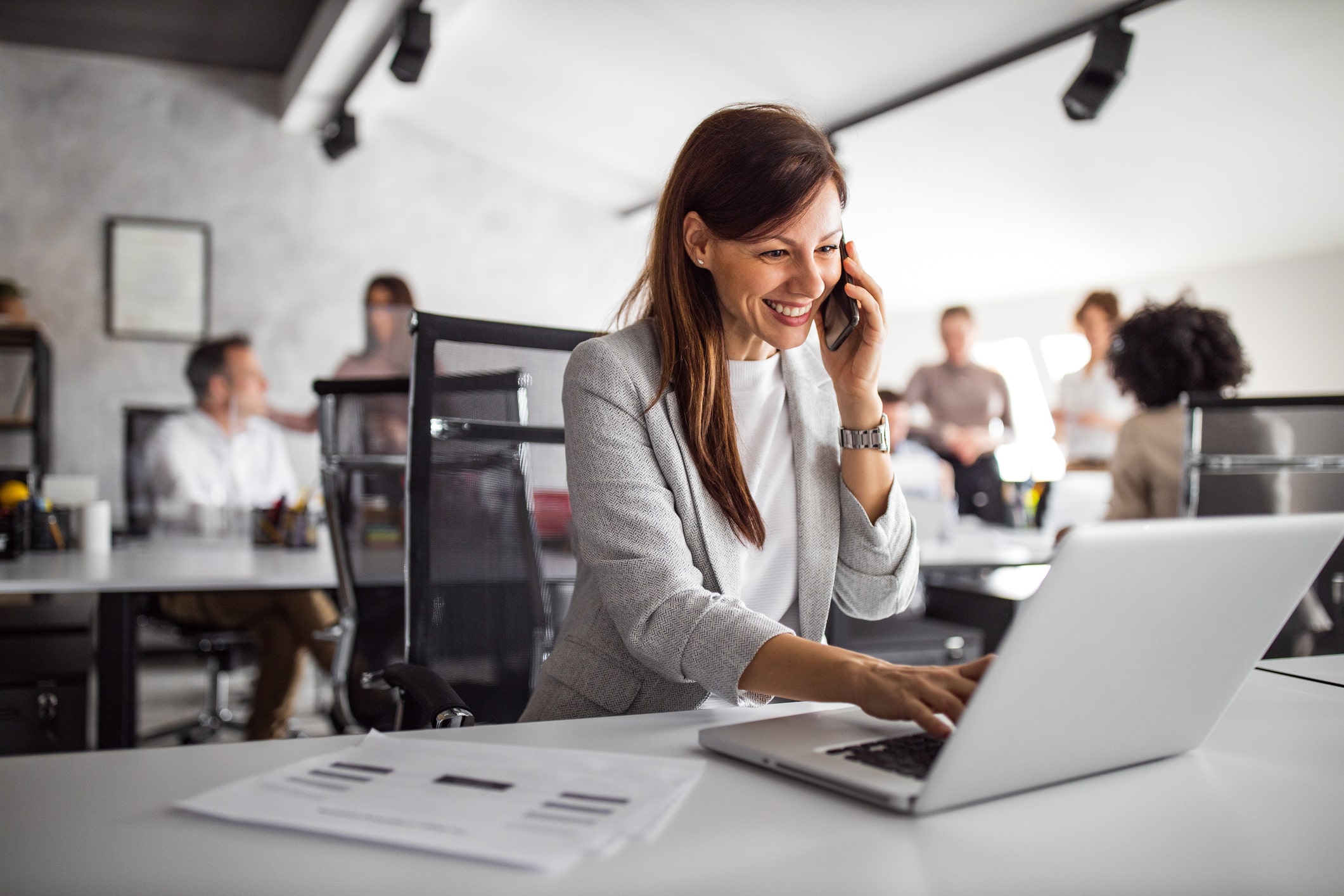 Woman at desk, engaged in phone conversation