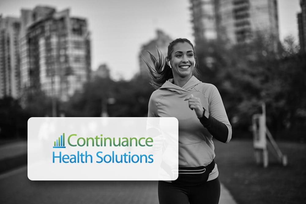 Woman jogging in city with 'Continuity Health Solutions' in background