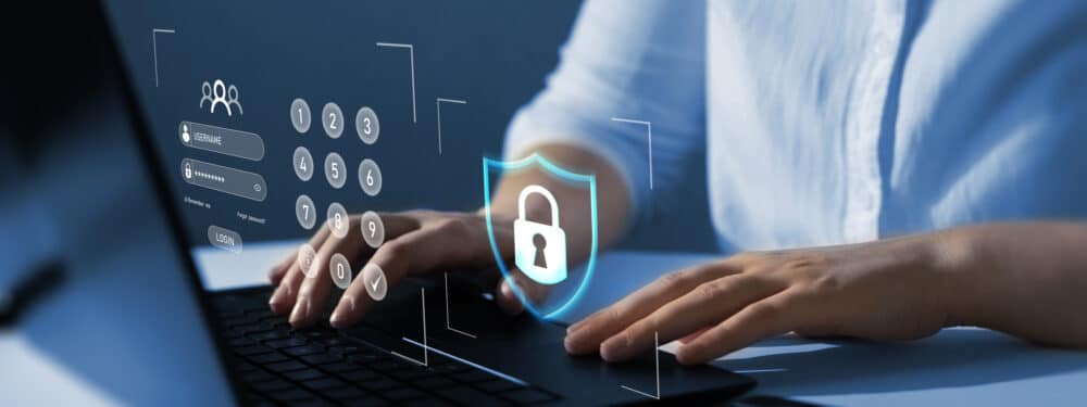 A graphic showing a shield protecting a computer from cyber attacks