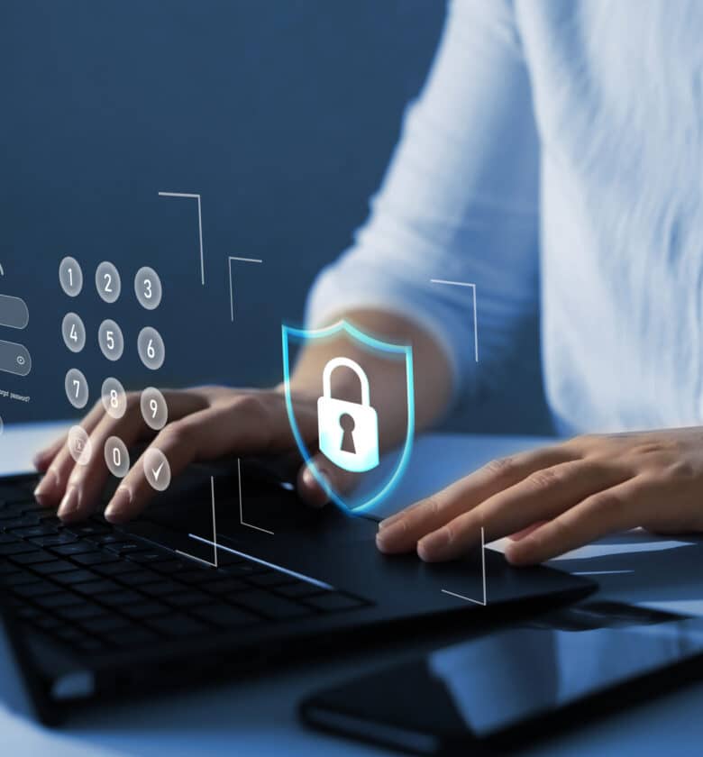 A graphic showing a shield protecting a computer from cyber attacks