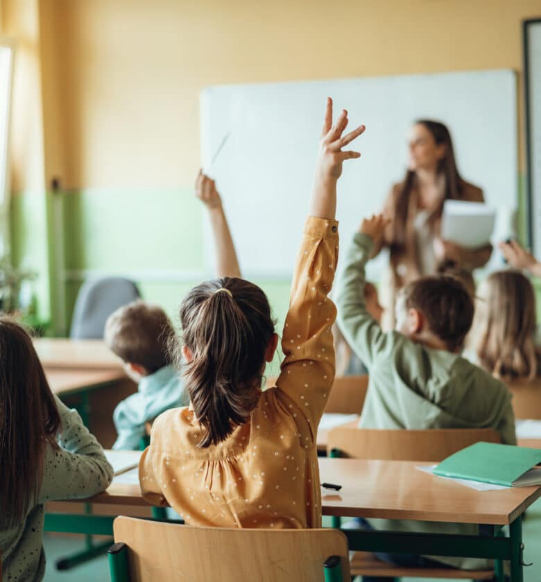 Children eagerly participate in class by raising their hands to ask or answer questions