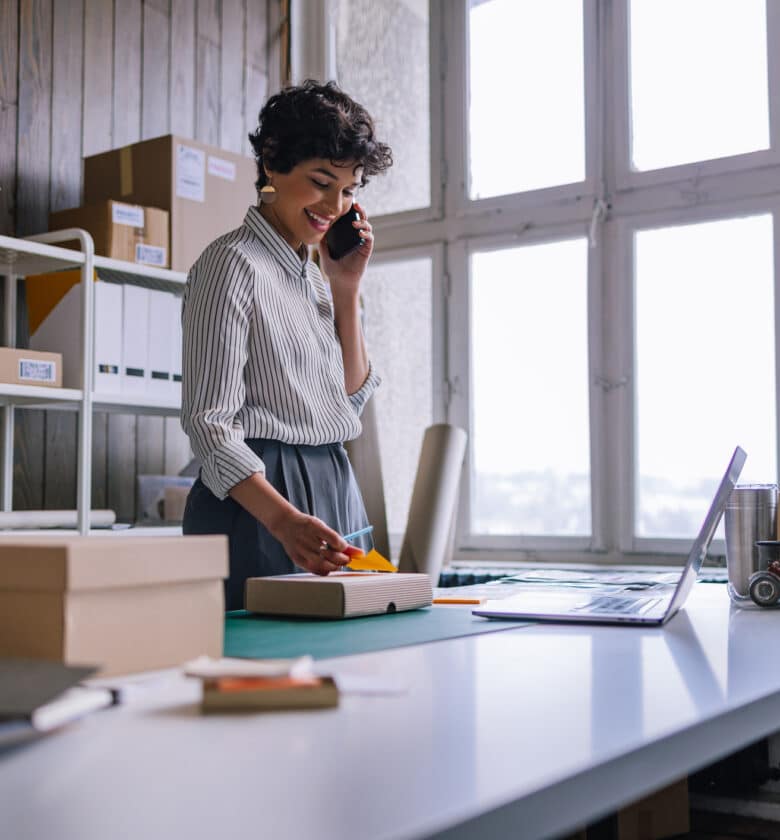 woman in front of a desk with a laptop and a box