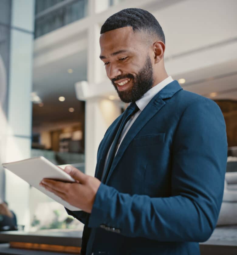 A businessman in formal attire operating a tablet device