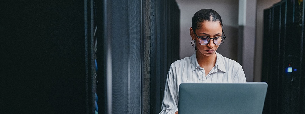 Women using a laptop in server room