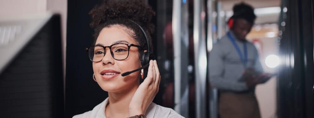 woman in glasses and a headset having a phone conversation