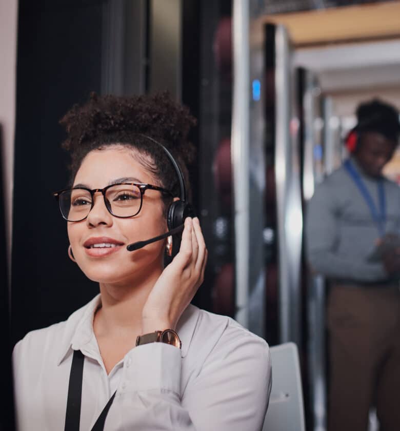 woman in glasses and a headset having a phone conversation