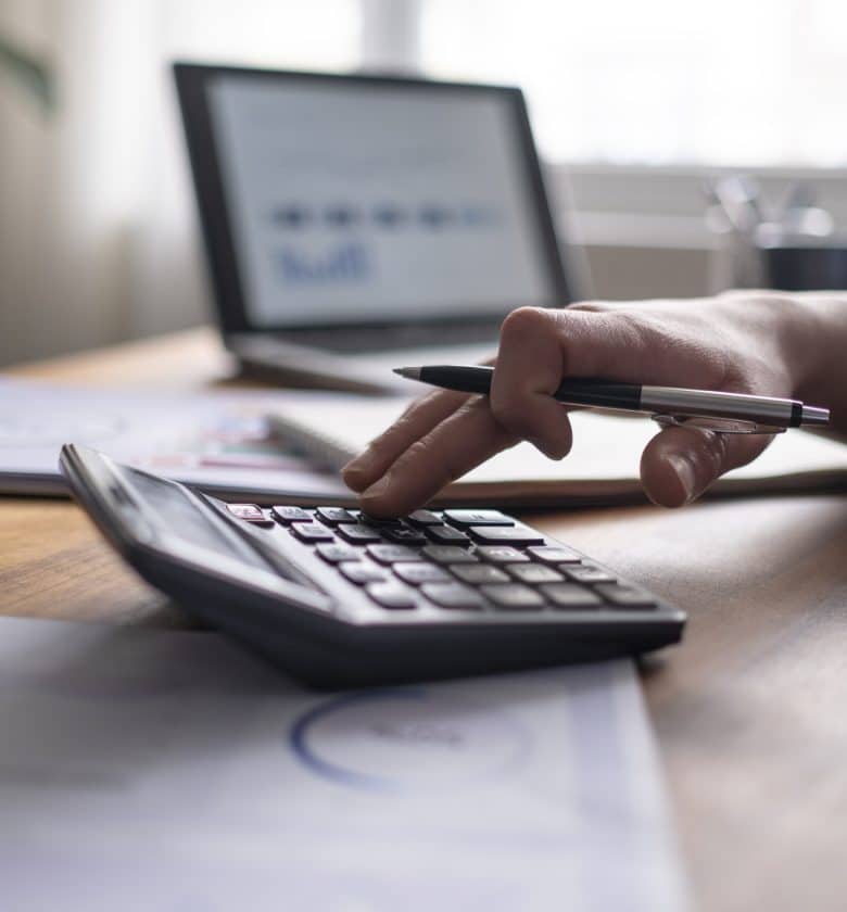 Person calculating on a calculator at a desk